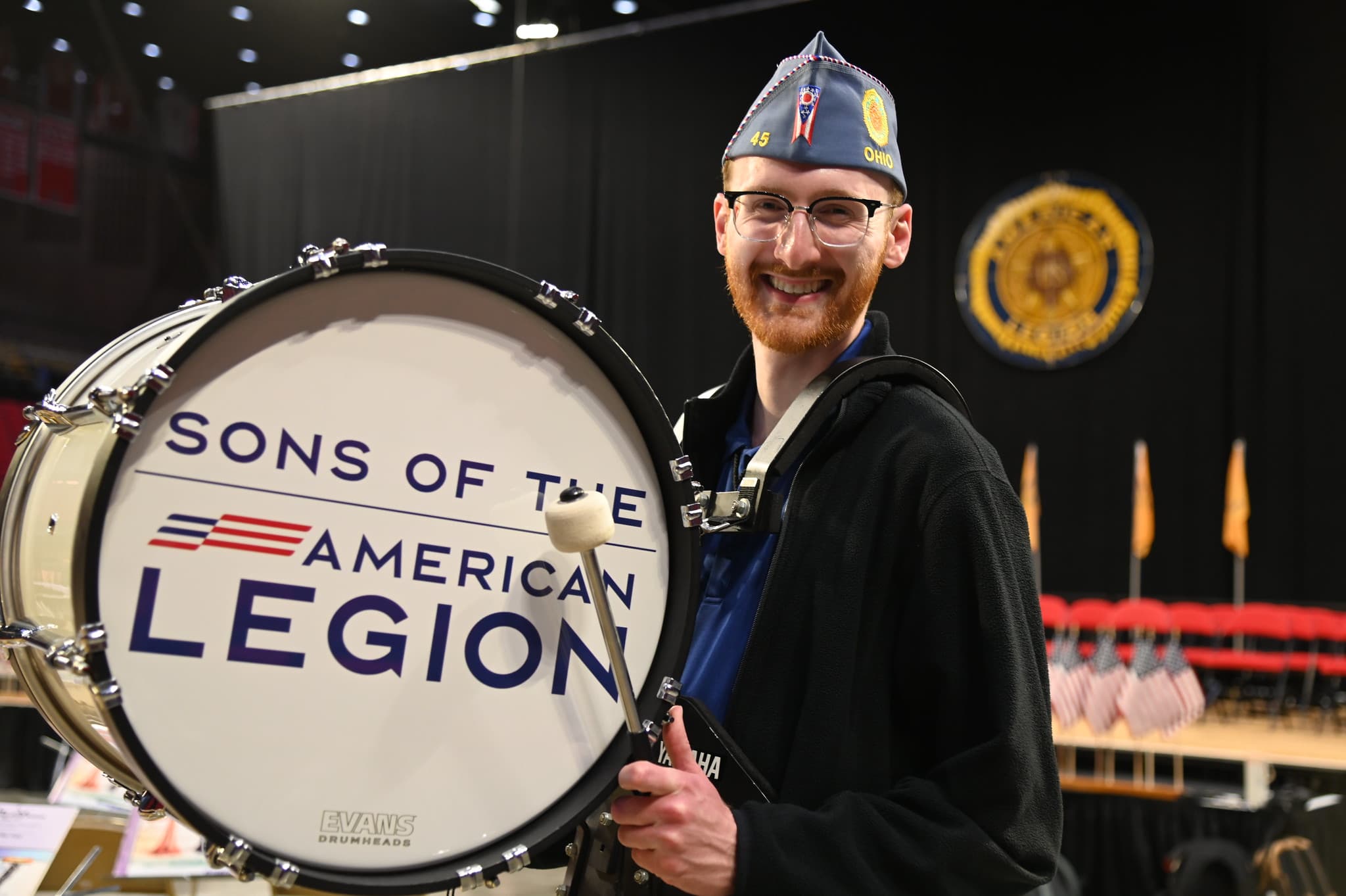 Man smiling holding a bass drum